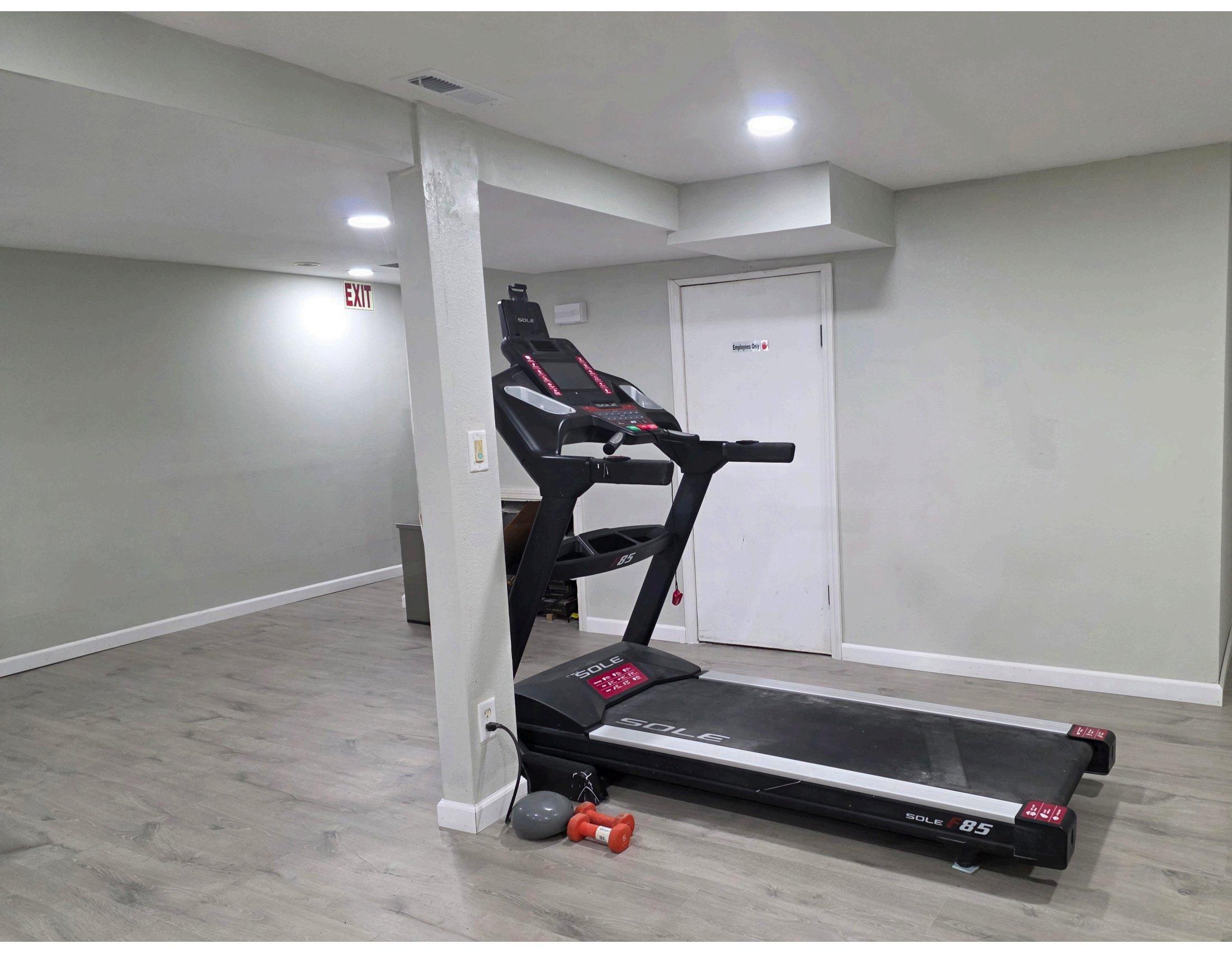 On-site fitness area with treadmill and light weights