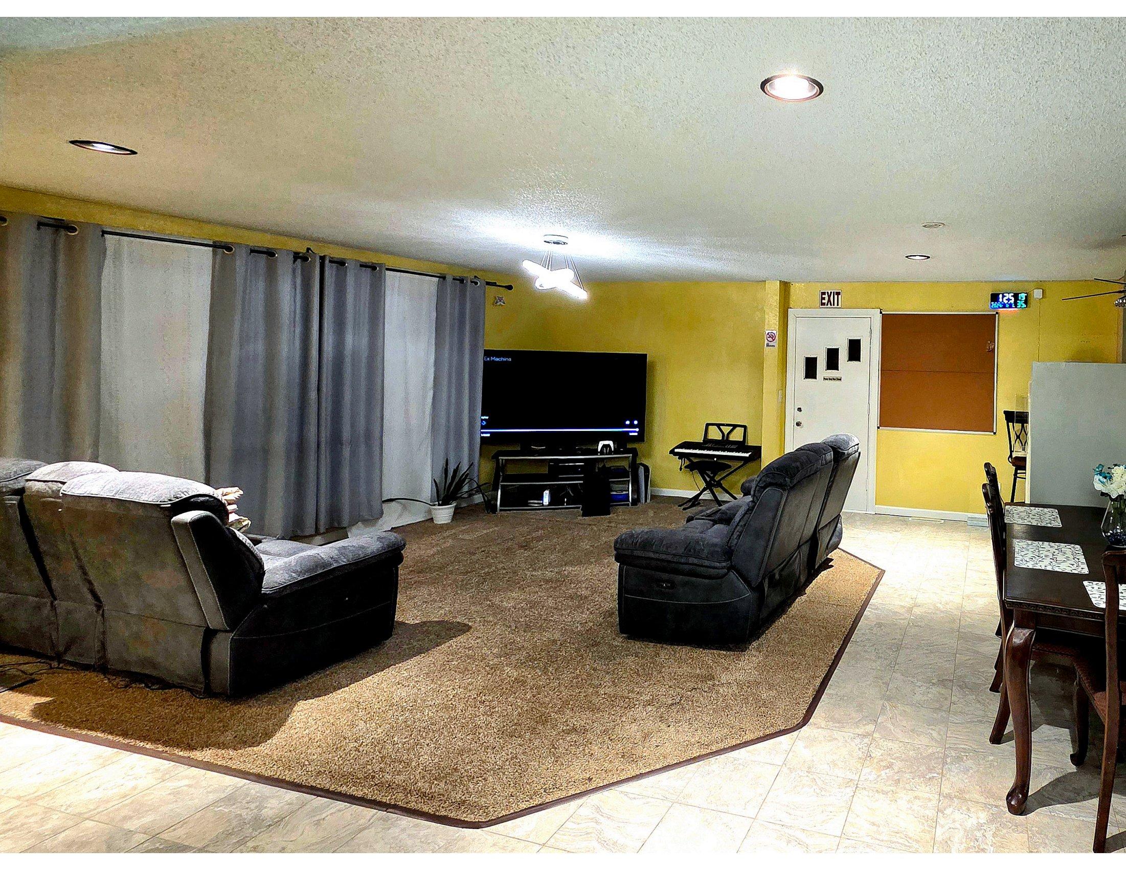 Living room from a second angle - gathering space with curtained windows